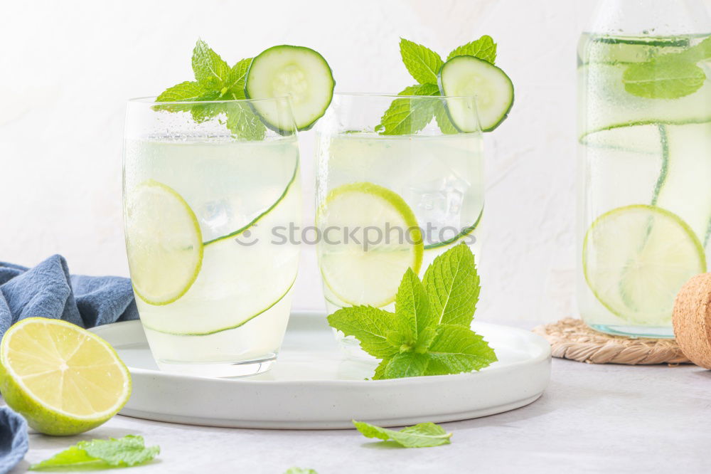 Similar – Cool soft drink with mineral water, tangerine, cucumber slices, ice cubes and green straw