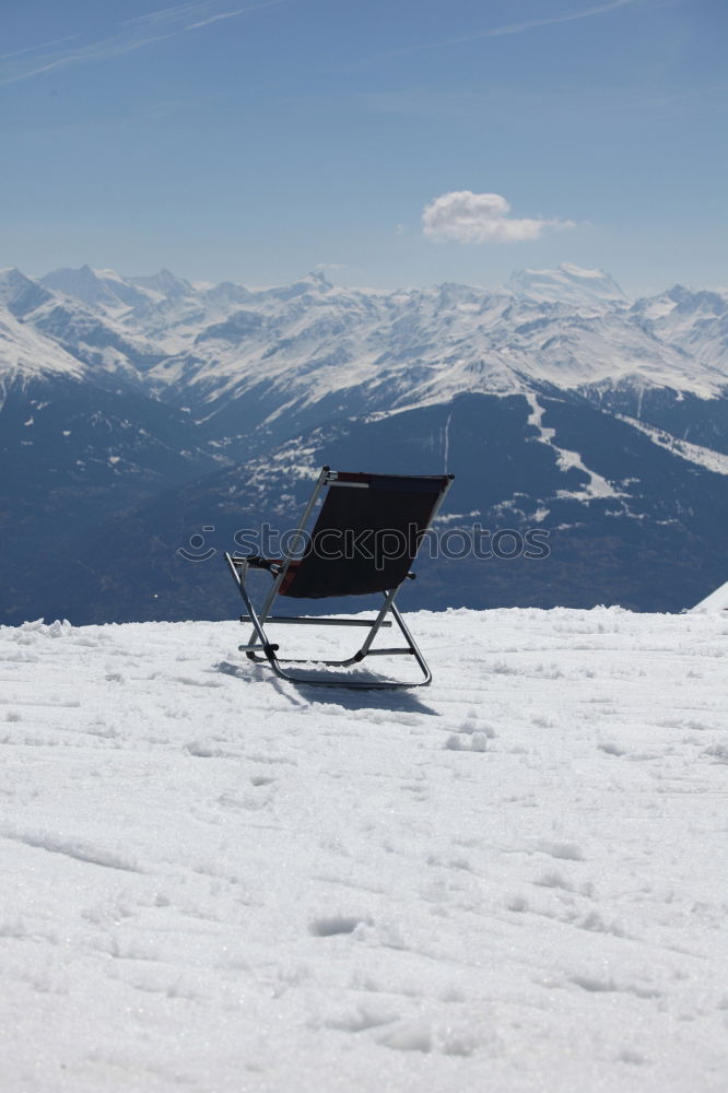 Similar – Sun loungers in the snow in front of mountain panorama