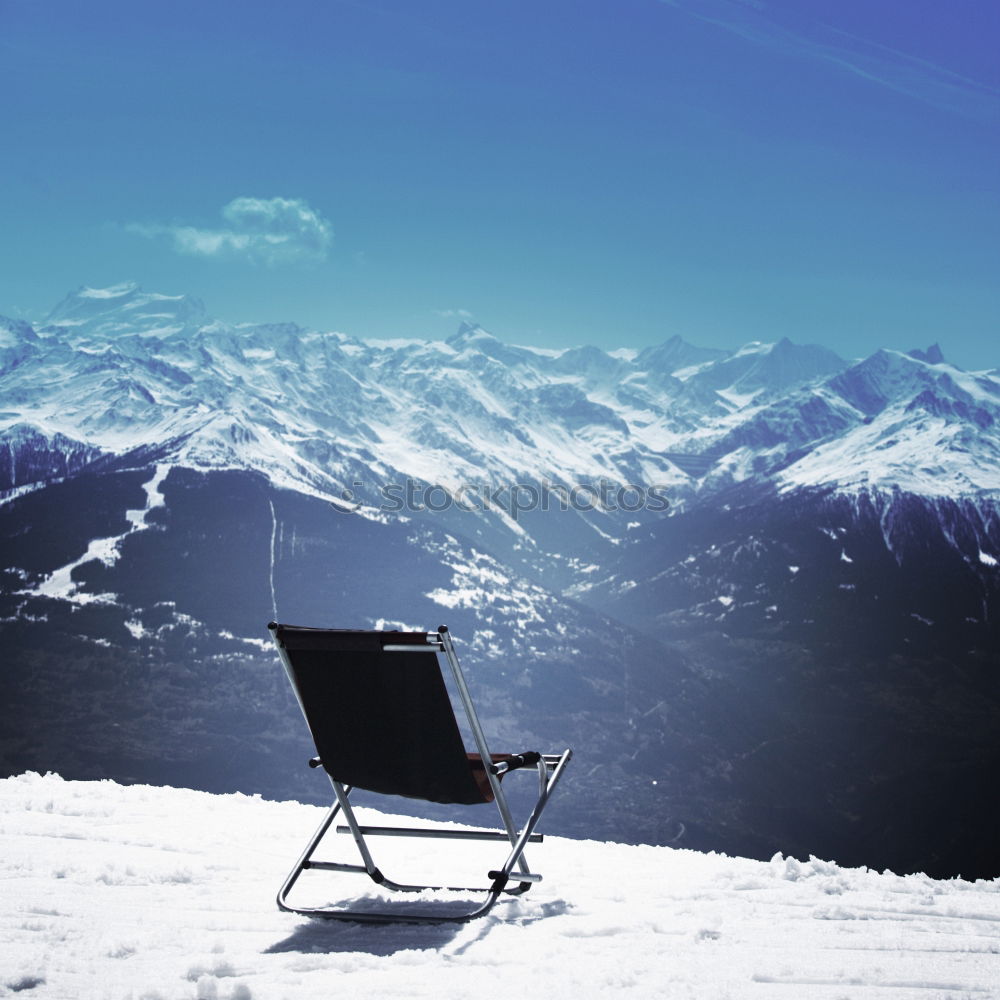 Similar – Sun loungers in the snow in front of mountain panorama