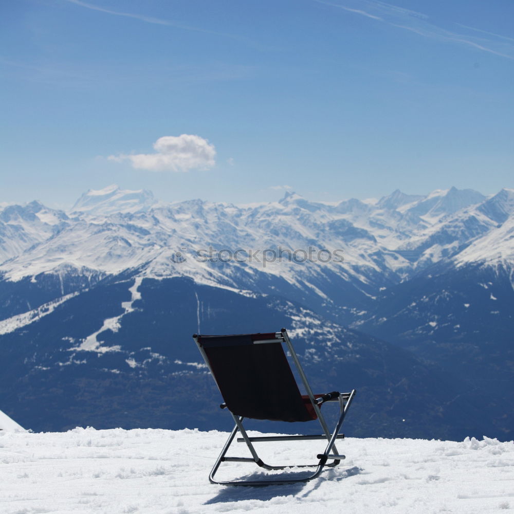 Similar – Sun loungers in the snow in front of mountain panorama