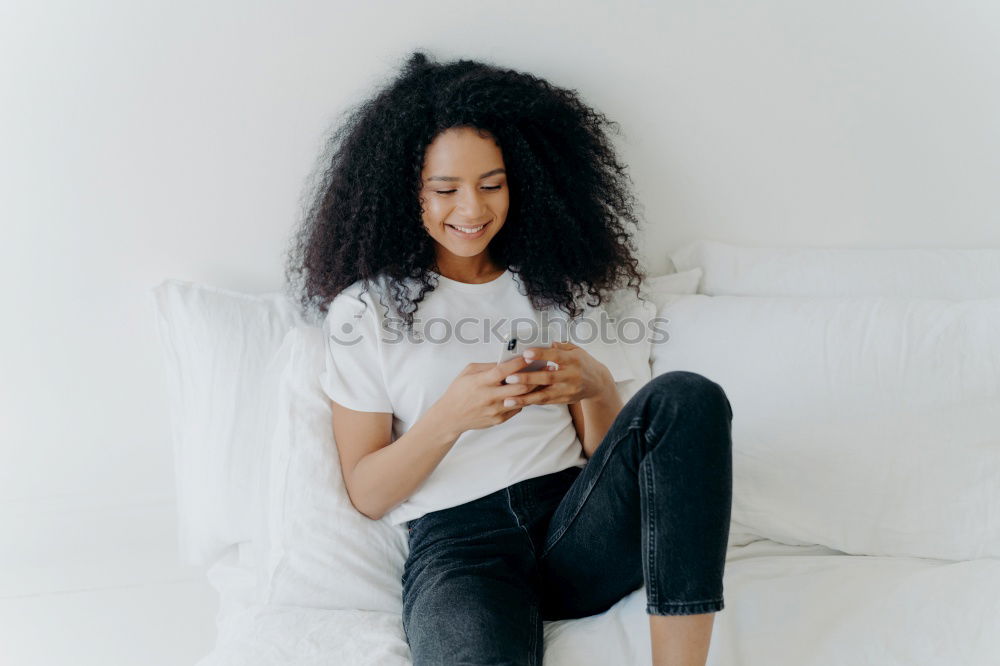 african happy woman lying on couch with laptop