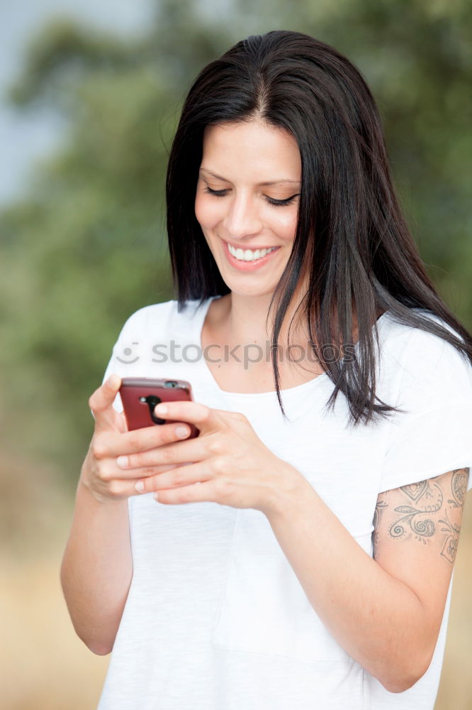 Similar – Young woman texting with a smartphone outdoors