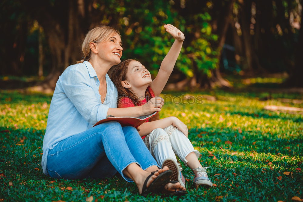 Similar – Mom reading a book her little daughter