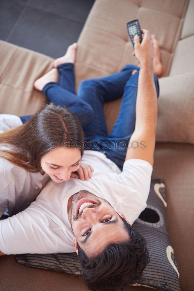 Similar – Couple laying on couch watching TV together