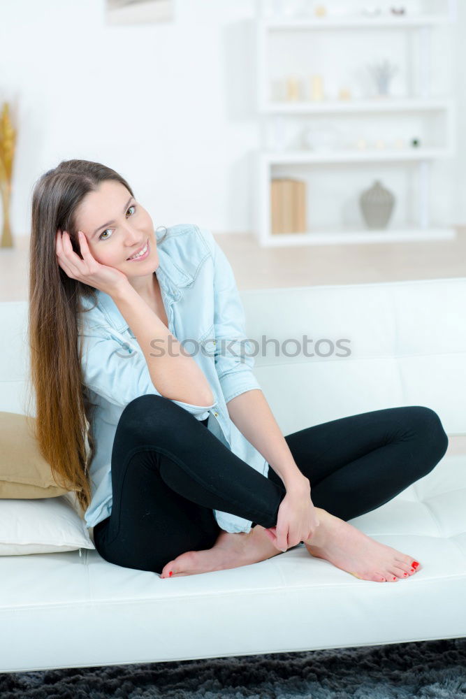 Similar – young tall woman sits on a light couch