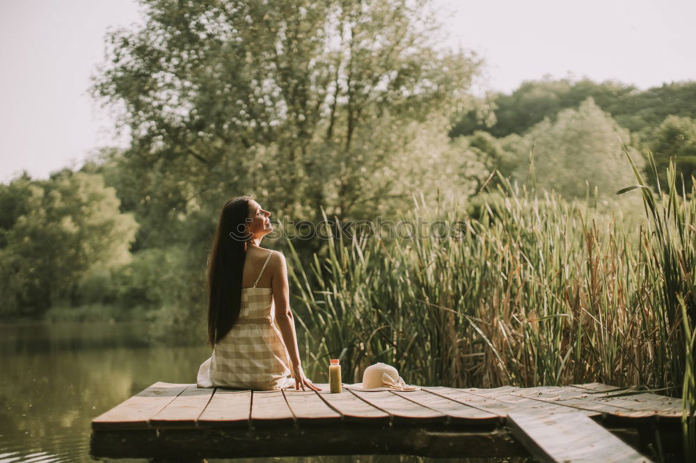 Similar – Image, Stock Photo analog medium format portrait of young woman in summer dress sitting barefoot among bushes in nature on a lakeside