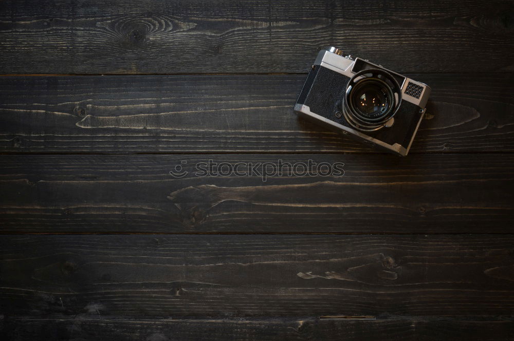 Similar – analogue 35mm camera on brown wooden table