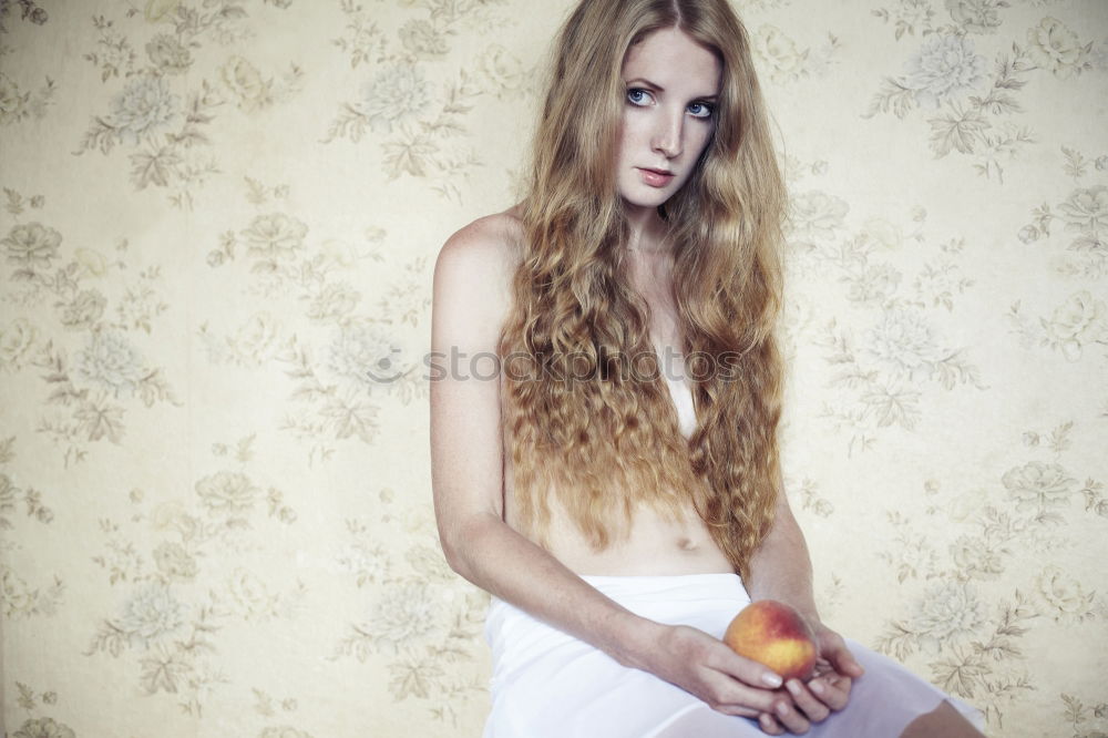 Similar – Young woman in undershirt sitting on a flowered couch and looking sideways into the camera