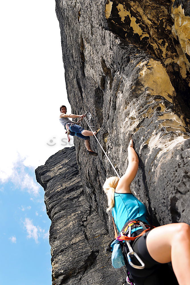 Image, Stock Photo Young couple rock climbing cliffs at the coast helping eachother