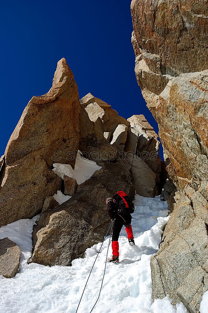 Similar – Climber helps another climber to reach the top of a mountain