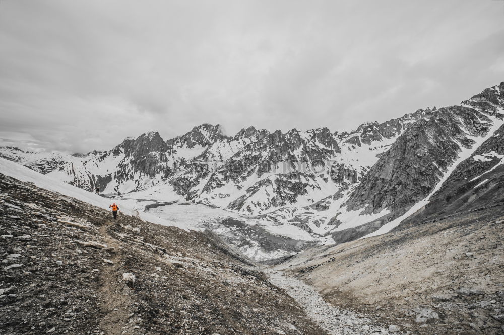 Similar – female hiker going up a mountain with snow.