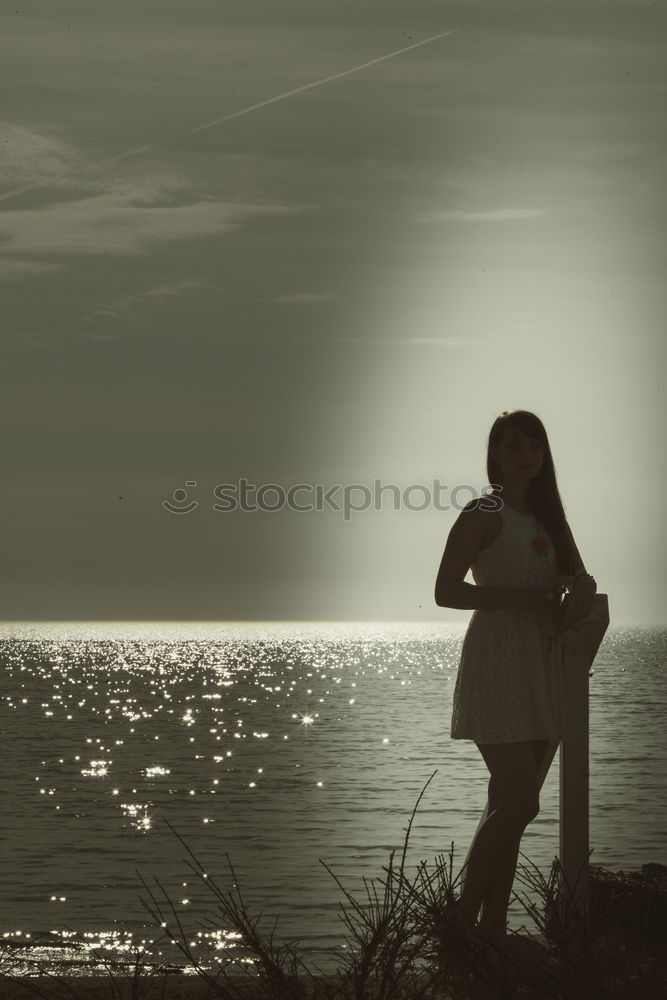 Similar – Image, Stock Photo Young woman is taking picture of sunset at the beach