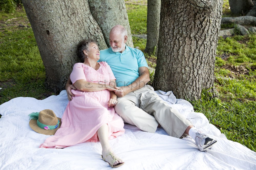 Similar – Image, Stock Photo 2 seniors in love are sitting on a bench in the vineyard and look into the Ahr valley. The man points to something.