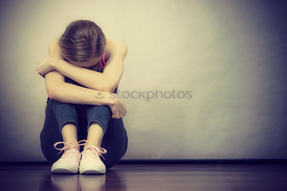 Similar – sad little girl sitting near the wall