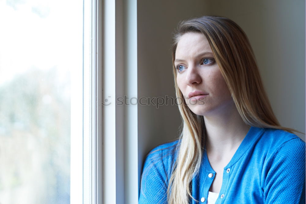 Similar – young, redheaded woman with curls looks out of the balcony window