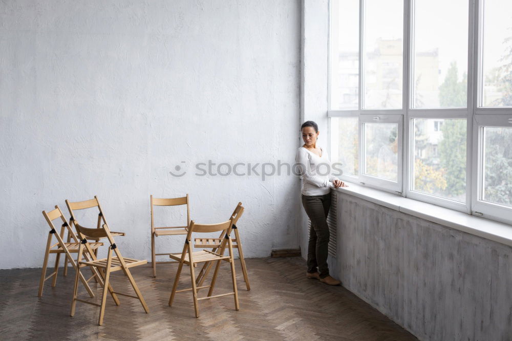 Similar – Young, tall, slim student sits on a chair at her desk and takes a short break