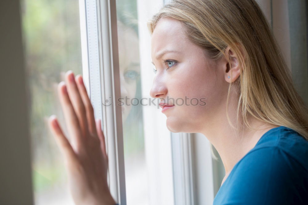 Similar – young, redheaded woman with curls looks out of the balcony window