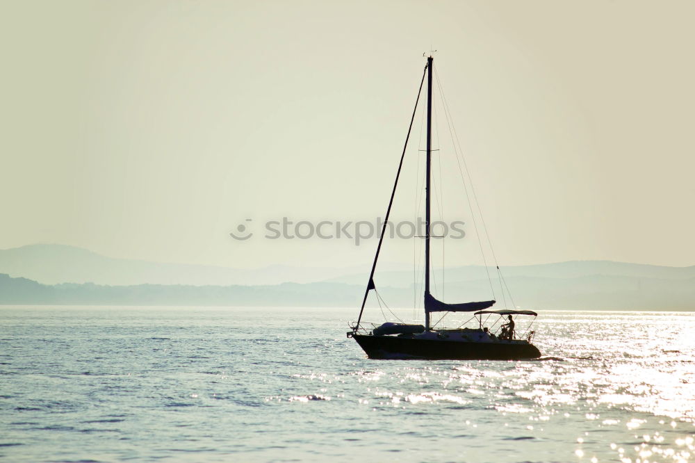 Image, Stock Photo Sailboat on a lake in the back light