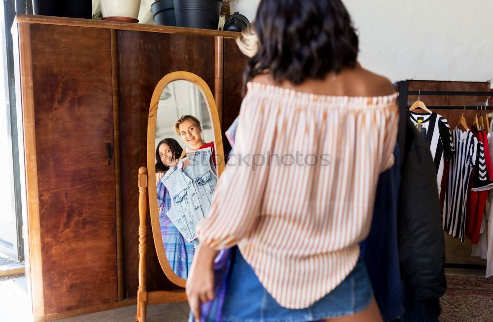 Similar – Young woman hanging clothes on coat hanger