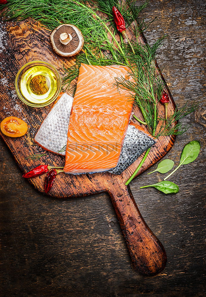 Similar – Salmon fish fillets on chopping board with fresh vegetables