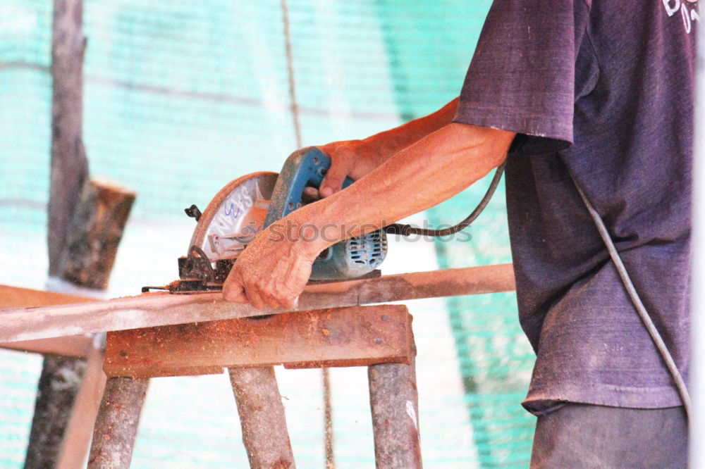 Similar – Carpenter cutting wooden board at his workshop