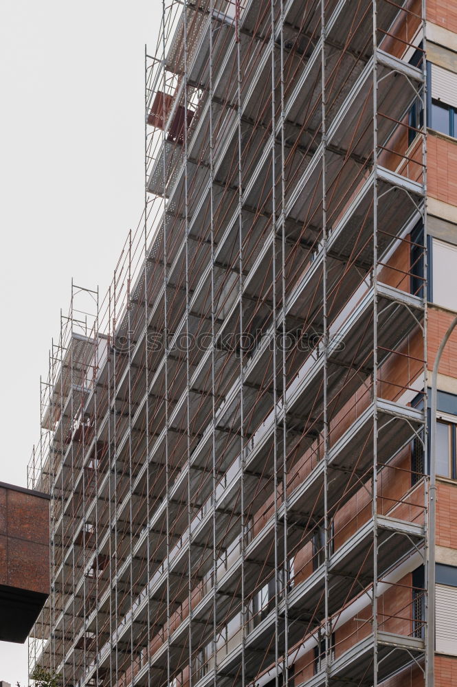 Foto Bild Bauzaun aus Holz vor dem Neubau eines Wohnhaus mit Baugerüst am ehemaligen Hafen in Offenbach am Main in Hessen