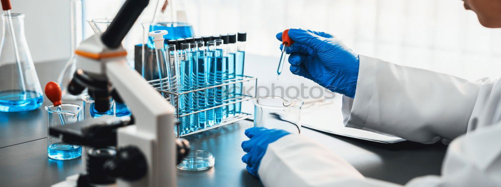 Worker putting liquid to test tube