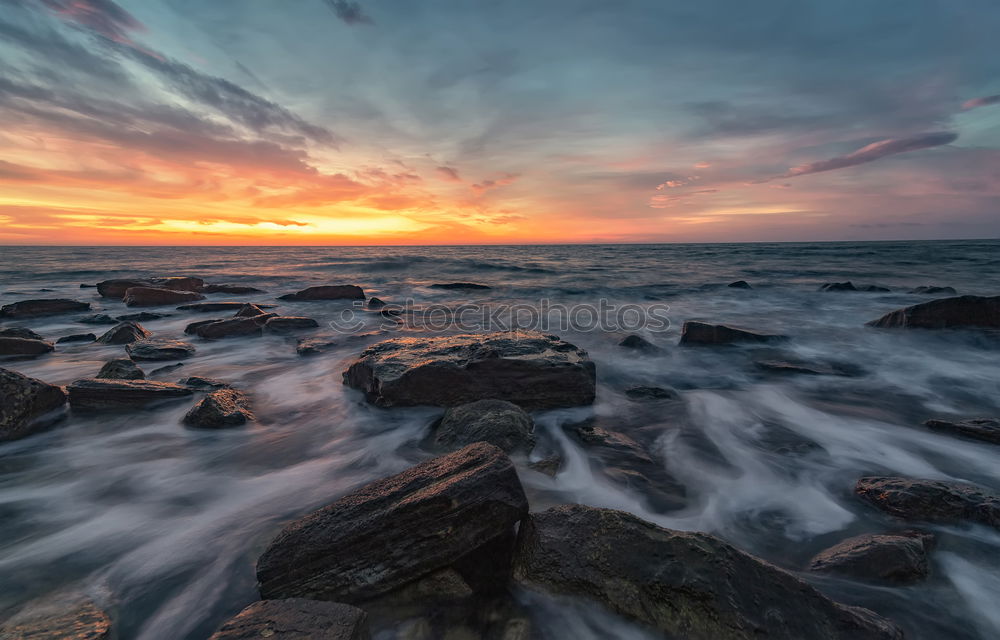 Similar – Sea crashes light waves into rocky bay, long exposure