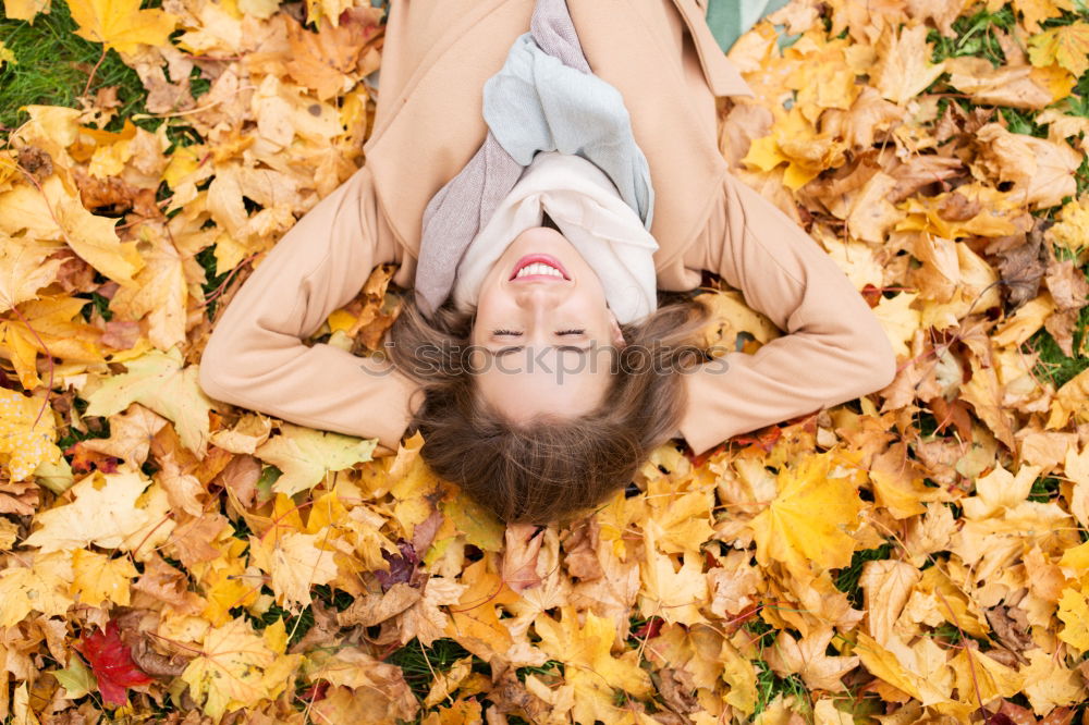 Similar – Image, Stock Photo Young woman lying down in the floor full of autumn leaves