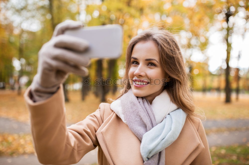 Similar – Young happy woman with green jacket taking selfie with her smartphone on the beach at sunset