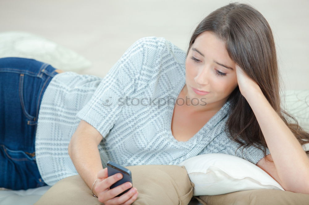 Similar – Young girl looking at mobile phone while sitting on bed