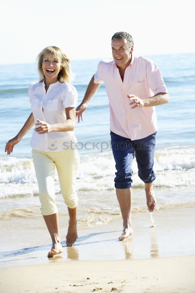 Similar – Senior man and woman having a run along the shore. Scene with sea, sand and trees. Healthy and active way of life