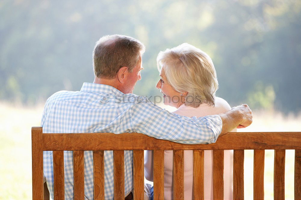 Similar – Image, Stock Photo 2 seniors in love are sitting on a bench in the vineyard and look into the Ahr valley. The man points to something.