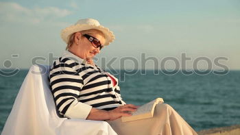 Similar – Image, Stock Photo Elderly woman on the beach wearing a straw hat