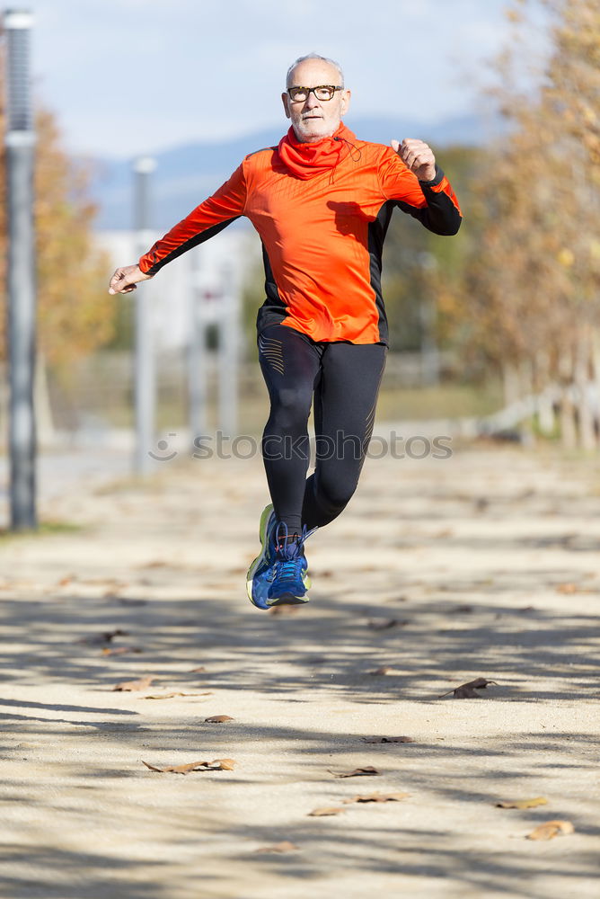 Similar – Senior runner man jumping arms up after running