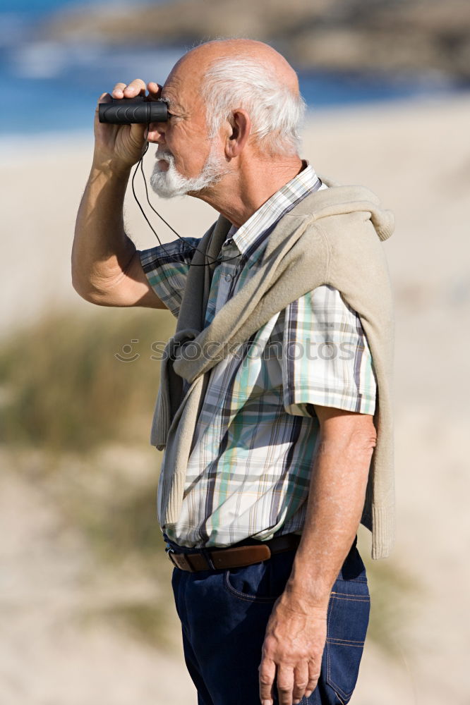 Similar – Rear view of a female senior citizen and two seniors sitting on gravel and looking out to sea