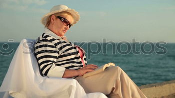 Similar – Image, Stock Photo Elderly woman on the beach wearing a straw hat