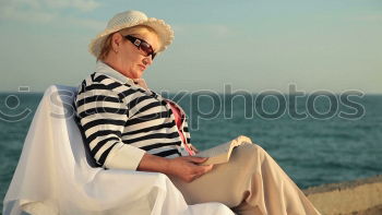 Similar – Image, Stock Photo Elderly woman on the beach wearing a straw hat