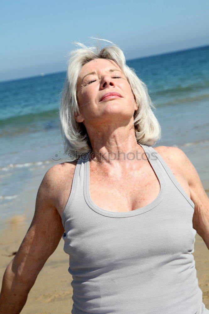 Senior old woman grey hair sitting by the swimming pool