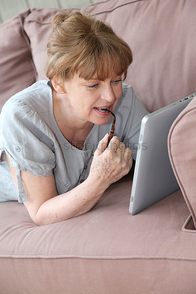 Similar – Elegante, reife Frau, die ein Smartphone benutzt, während sie auf dem Sofa sitzt