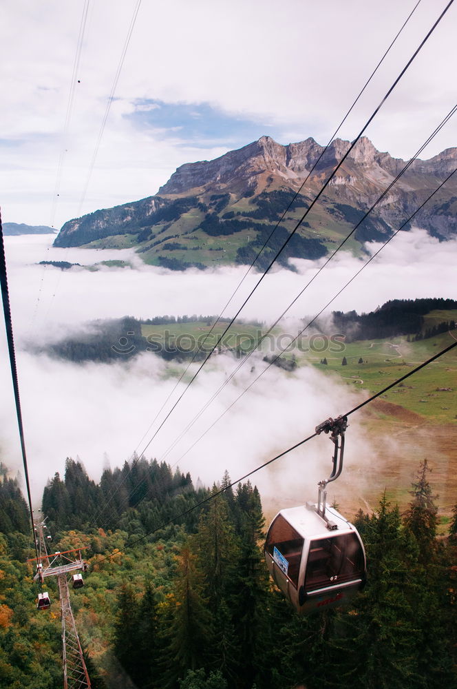 Similar – Chairlift with empty 2-seater chair and view of snow-free hill country