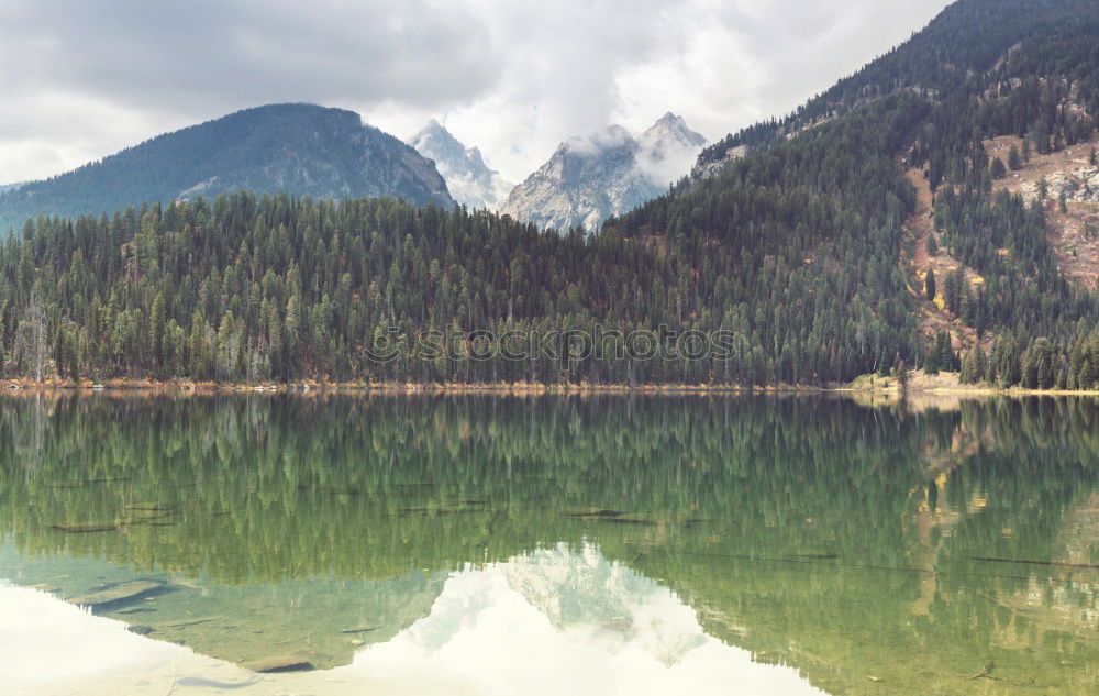 Wonderful lake between hills in snow and cloudy sky