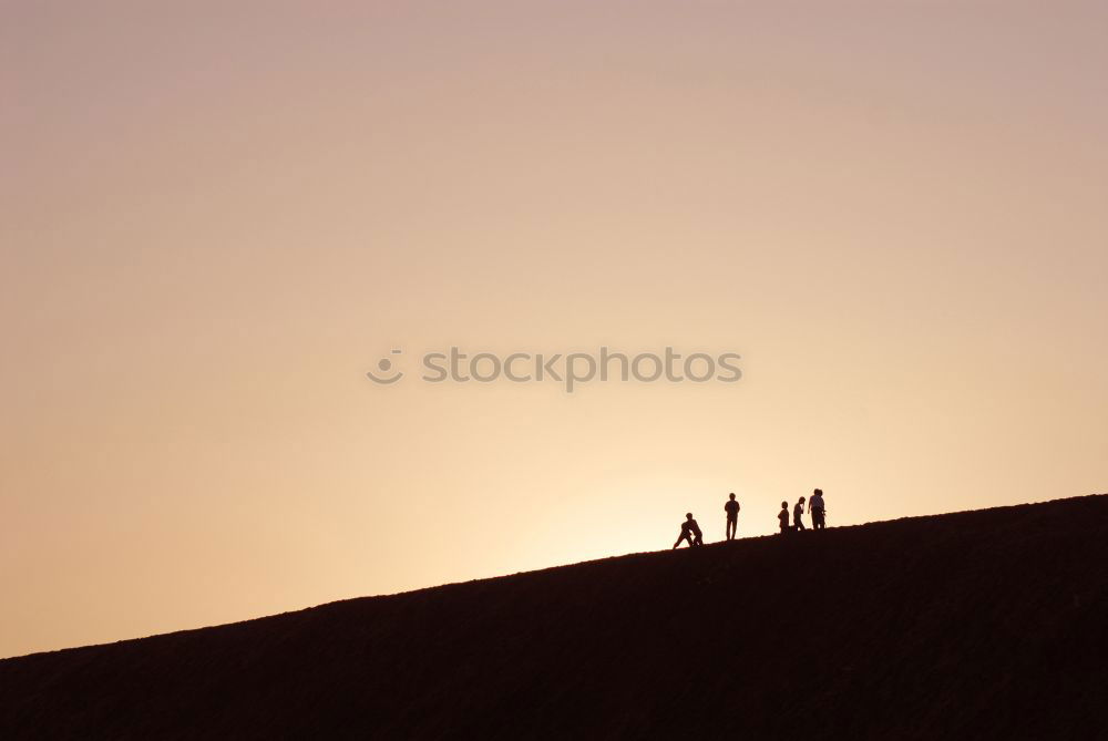 People on mountain before sunset