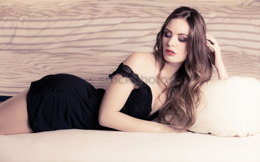 Similar – Young woman in undershirt sitting on a flowered couch and looking sideways into the camera