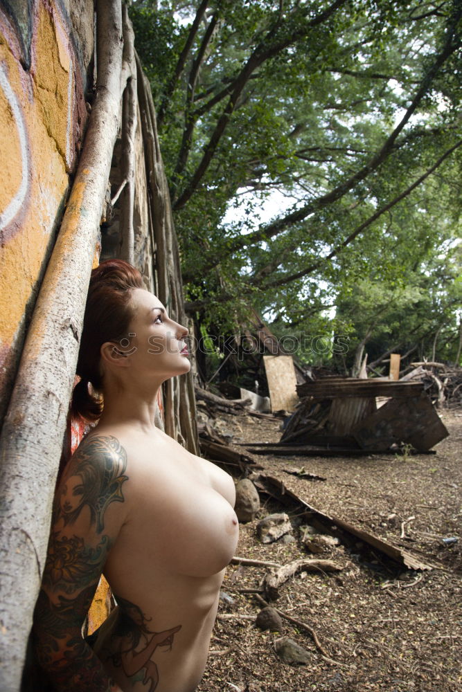 Image, Stock Photo Young tattooed woman with turquoise hair sits barefoot in beach forest leaning against tree and smiles at camera