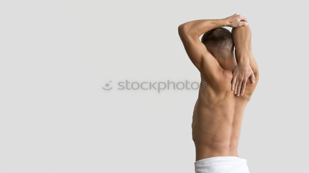 Similar – young woman with very short hair stands naked in front of light turquoise wall in pose with half raised arms