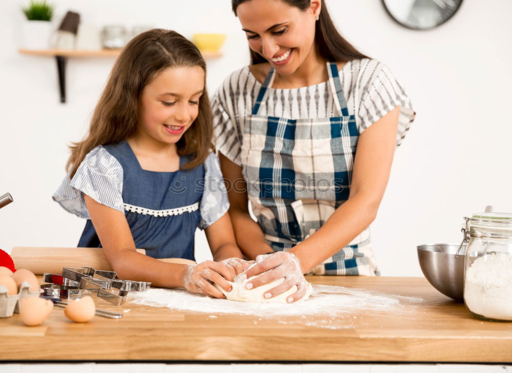 Image, Stock Photo Little sisters cooking with her mother in the kitchen.