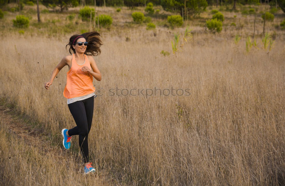 Similar – Fit middle-aged woman walking through a field