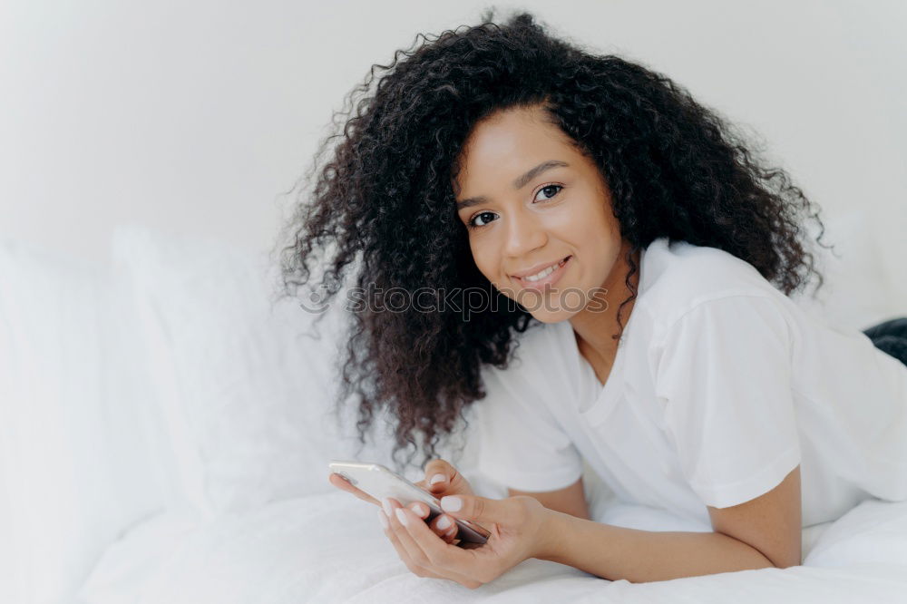 Similar – Beautiful black woman with curly hair smiling and lying on bed looking at the camera