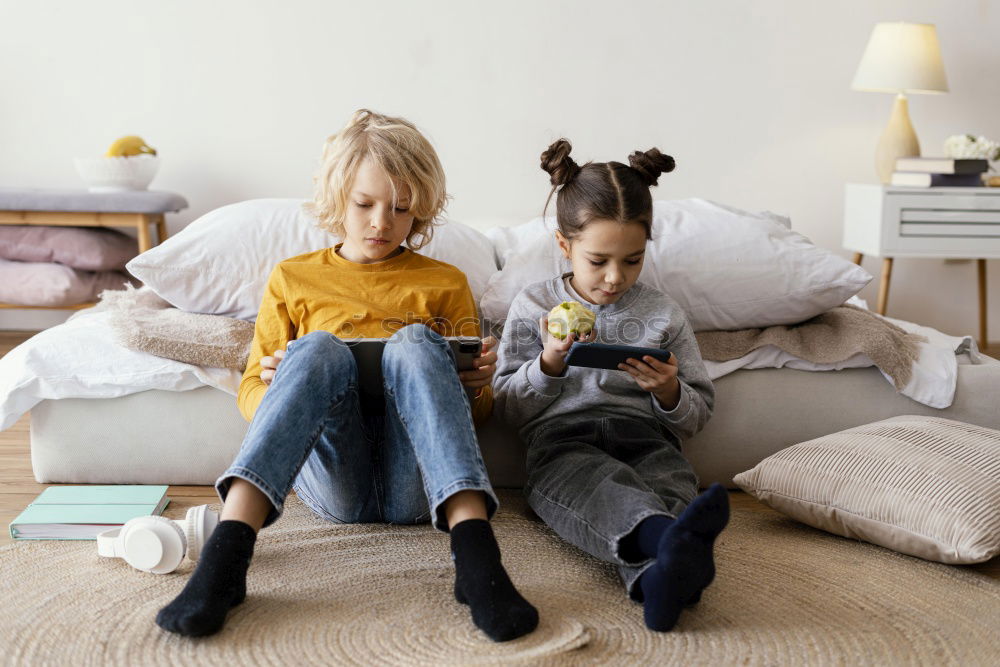 Similar – Image, Stock Photo Girl and boy reading a book sitting on the bed